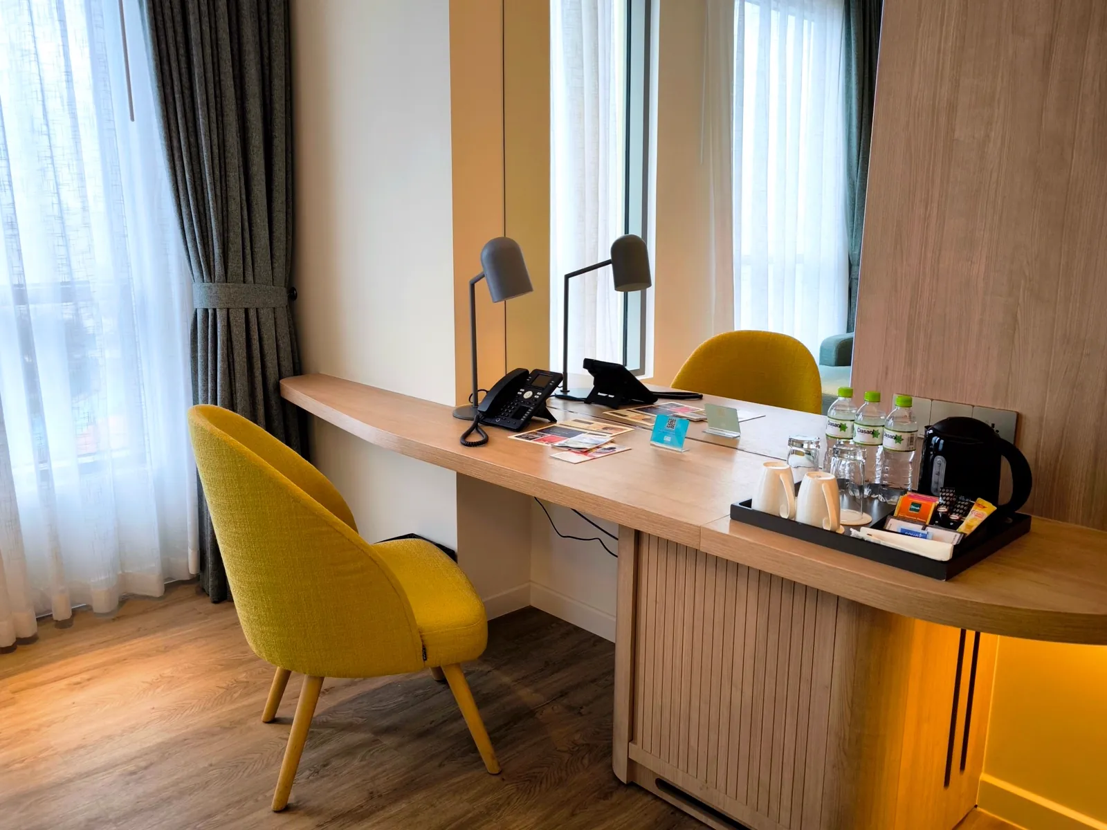 Modern hotel room with desk workspace and natural window light